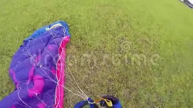 专业跳伞员在降落后在绿野上系降落伞。 极限运动。